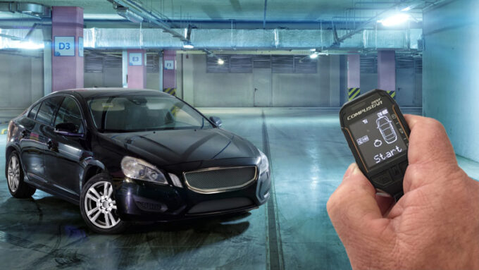 A car in a garage and a man's hand holding a remote start